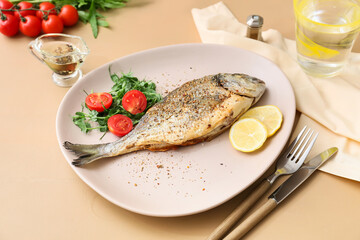 Plate with fried dorado on color background