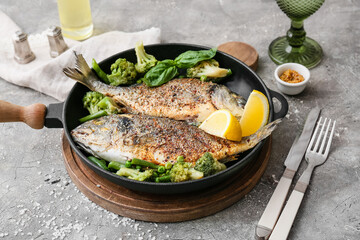 Frying pan with dorado on grunge background