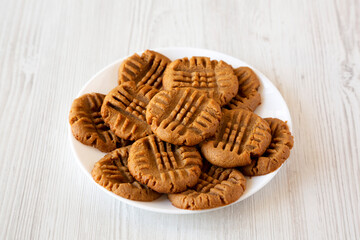 Homemade Peanut Butter Cookies on a plate on a white wooden surface, side view.