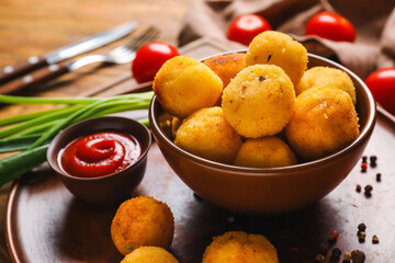 Naklejka na ściany i meble Bowl with fried potato balls and tomato sauce on tray