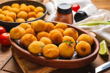 Naklejka na ściany i meble Tray with tasty fried potato balls on board