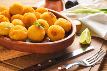 Tray with tasty fried potato balls on board