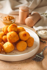 Plate with fried potato balls on color background