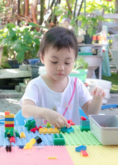 Preschooler child playing creative colorful building blocks toy at home.