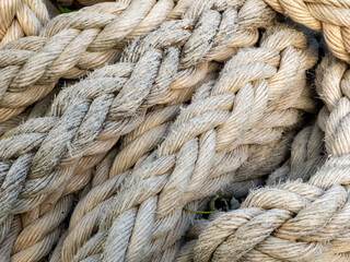 Thick braided rope is tied with a skein. Fishing rope background.