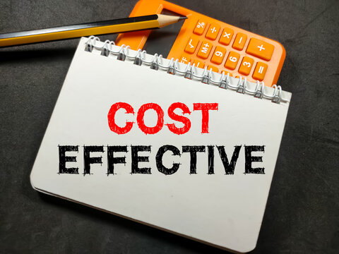 Business concept.Text COST EFFECTIVE on notebook with pencil and calculator on black background.