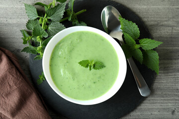 Concept of healthy food with nettle soup on gray textured table
