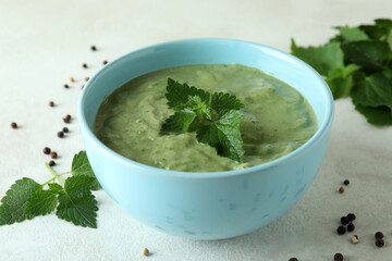 Concept of healthy food with nettle soup on white textured table