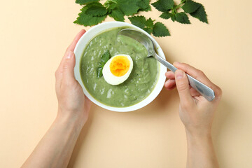 Concept of healthy food with nettle soup on beige background, top view