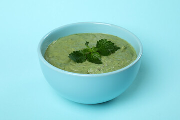 Plate of fresh nettle soup on blue background