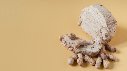 Peanut halva and peanut nuts on a light brown background top view of kopi space. Halva oriental sweets	
