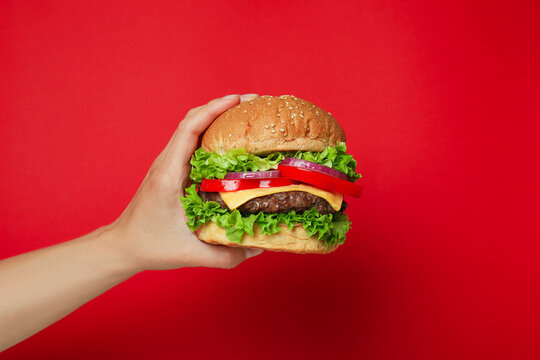 Concept of tasty food with burger on red background