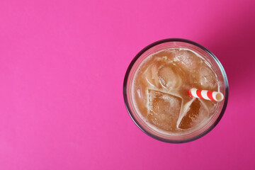 Glass of ice coffee on pink background