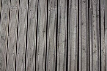 Close up of gray wooden planks with screws. Vertical position of panels. Wood texture. Background or backdrop.
