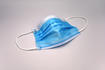 Surgical mask against a gray background
