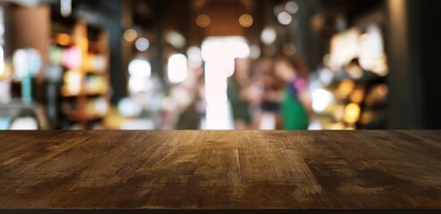 Empty wooden table in front of abstract blurred background of coffee shop . 

