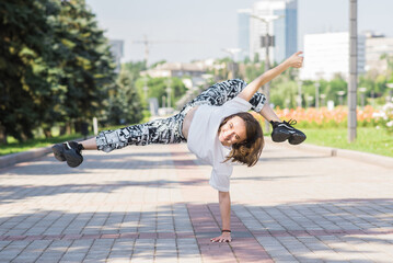 Attractive beautiful caucasian girl is dancing on the street. Sport, dance, urban culture. Fashion lifestyle.