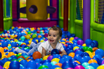 Obraz premium cute and happy little girl laughing and playing in an indoor playground in a shopping mall in Dubai, United Arab Emirates.