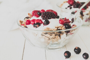 Granola with yogurt, strawberries, blackberries and blueberries. Vintage Instagram style effect