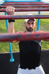 Obraz premium Fitness Model doing pull ups on Monkey Bars