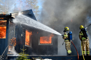 Firefighters trying to put out flames cabin on fire