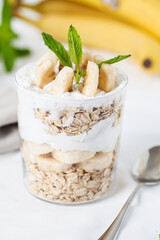 Banana breakfast with oat in a jar on white background..