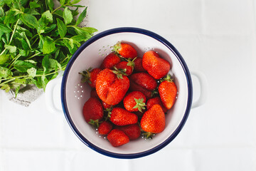 Fresh strawberries in a colander with mint herb