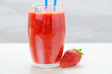 A glass of fresh berries fruit and smoothies on white . Blueberries and strawberries.