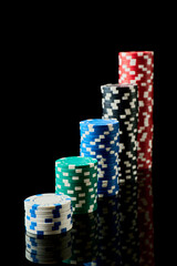 Stack of Casino gambling chips isolated on black reflective background