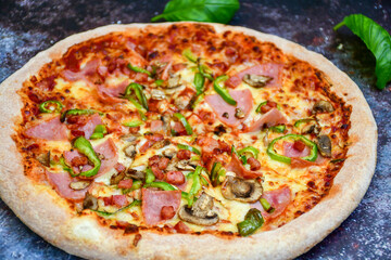  Close up of    hot italian pizza   classic ham. Fresh basil,tomato sauce ,mozzarella cheese , mushrooms and  minced meat .Concept poster for Restaurants or pizzerias. Top view