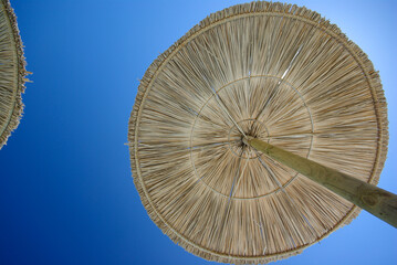 thatch umbrella on the background of the blue sky