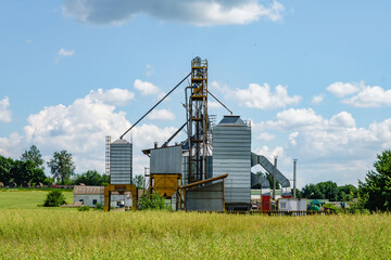 Modern Granary elevator. Silver silos on agro-processing and manufacturing plant for processing drying cleaning and storage of agricultural products, flour, cereals and grain.