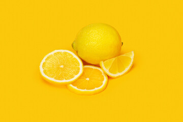 Lemon with slice on yellow background. High quality photo