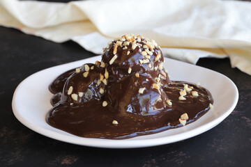 Chocolate profiteroles dessert on a dark wooden background