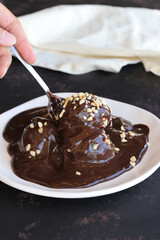 Chocolate profiteroles dessert on a dark wooden background