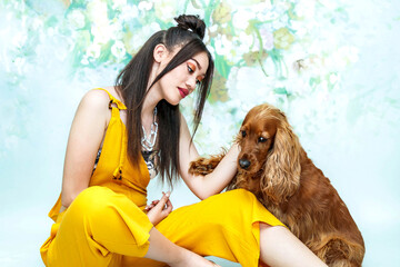 Beautiful female Golden Cocker Spaniel and female young human model in a floral studio setting. 