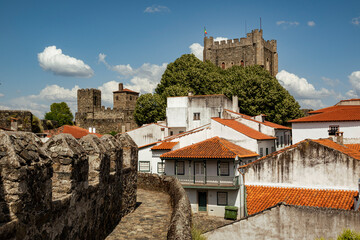 View towards the tower of „Castelo de Bragança“ castle surrounded by white houses with red...