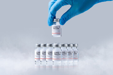 Hand holding frozen cold Vaccine vials for Covid-19 vaccine in laboratory. Group of Coronavirus...