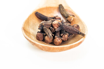 Dry brown spice cloves on wooden spoon - cooking ingredients