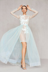 Fototapeta premium Beautiful young woman in transparent tulle dresses with lace