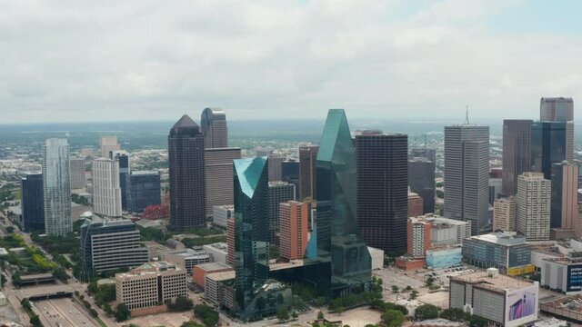 Forwards reveal of modern tall buildings at Fountain place with glass facades and irregular shape. Aerial view of downtown. Dallas, Texas, US.