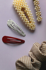 Various hair accessories on lilac background. Flat lay.