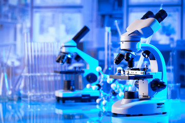 Laboratory investigations concerning covid pandemy. Microscope, glass tubes and beakers in the...