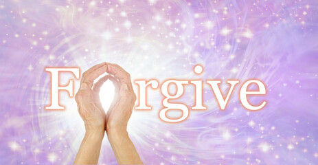 Forgiveness concept banner -  hands making the O in the word FORGIVE against a lilac ethereal wispy...