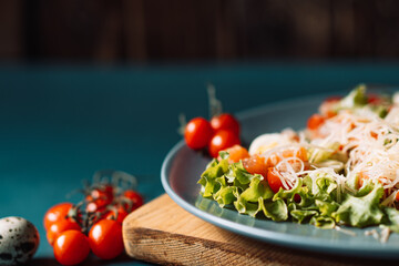 Blue plate with salad on the table with cherry tomatoes