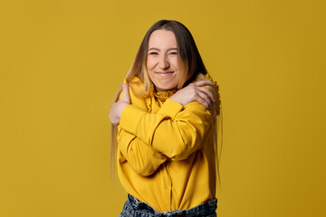blonde woman hugging oneself happy and positive