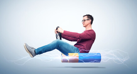 A man with glasses drives a car on electric batteries while holding a car steering wheel,...