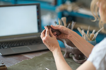 artisan pottery tutor in art studio. woman ceramist teaches an online lesson or leads a video master class on creating ceramic products