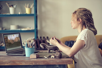 artisan pottery tutor in art studio. woman ceramist teaches an online lesson or leads a video master class on creating ceramic products