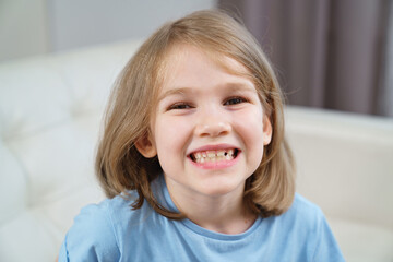 Little girl shows a reeling tooth. changing milk teeth to indigenous teeth.